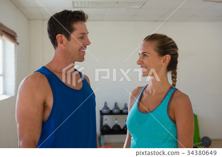 Smiling athletes talking in gym Smiling athletes talking in gym 34380649