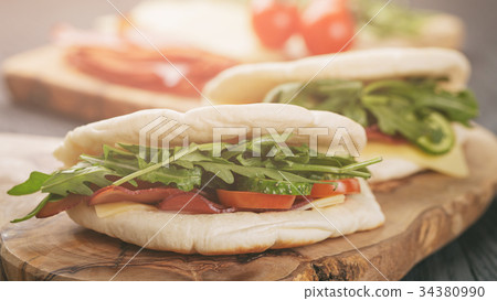 rustic sandwiches with ham arugula and tomatoes in 34380990