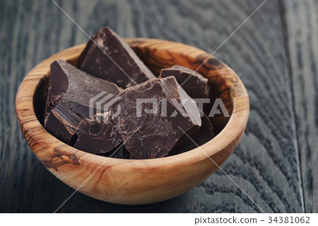 dark chocolate chunks in wooden bowl 34381062