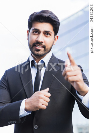 Angry businessman in suit with hand raised 34381268