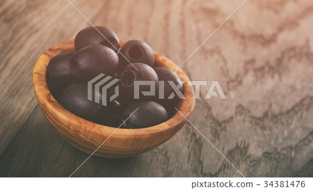black olives from can in bowl on table 34381476