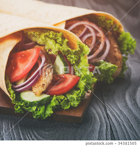 pair of fresh juicy wrap sandwiches with chicken pair of fresh juicy wrap sandwiches with chicken 34381505