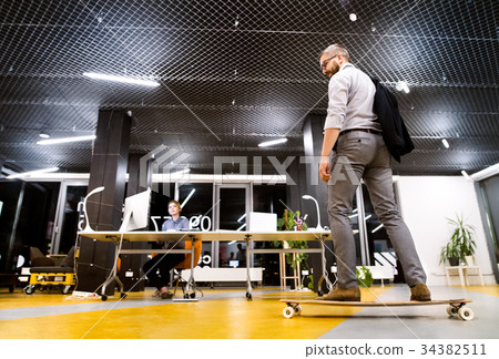 Businesspeople in the office at night working late 34382511