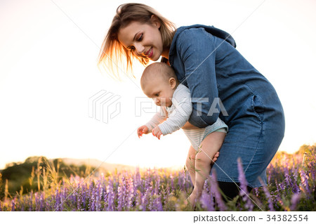 Young mother in nature with baby son in the arms. Young mother in nature with baby son in the arms. 34382554