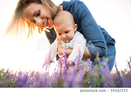 Young mother in nature with baby son in the arms. Young mother in nature with baby son in the arms. 34382555