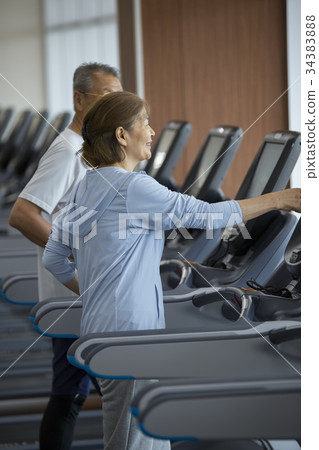 Senior couple walking on running machine 34383888