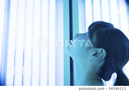 Woman entering a tanning machine 34384111