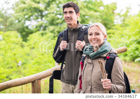 Man and woman hiking with rucksack on forest trail 34384617