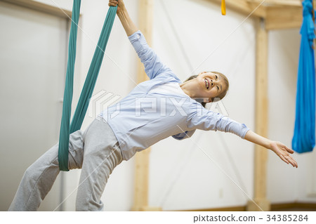 Senior lady experiencing aerial yoga 34385284