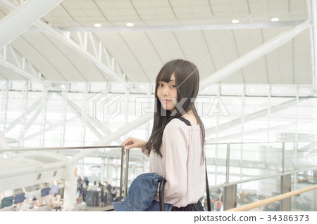 A woman standing in the lobby of the airport A woman standing in the lobby of the airport 34386373