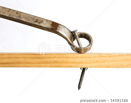 A wrench being used to pry a nail from wood 34391588