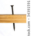 A sharp screw in a piece of wood 34391591