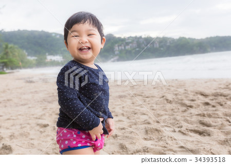Baby cute girl laughing with swiming suit on beach 34393518