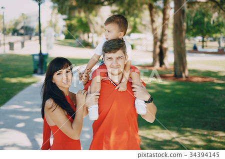 beautiful family in red walking down the street beautiful family in red walking down the street 34394145