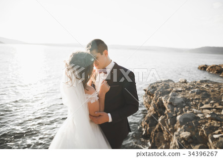 Wedding couple kissing and hugging on rocks near Wedding couple kissing and hugging on rocks near 34396267