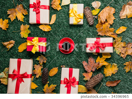 Cup of coffee and autumn yellow leaves with gifts 34396965