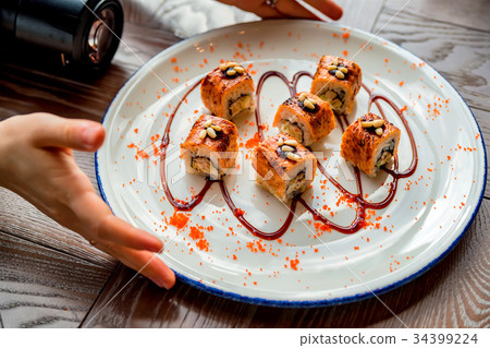 Food photographer takes picure of sushi rolls 34399224