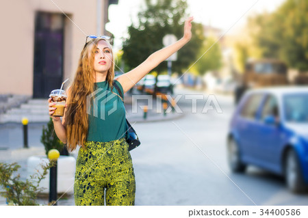Girl calling taxi on the street 34400586