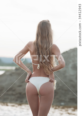 Girl on the sandy beach in a bathing suit 34412943