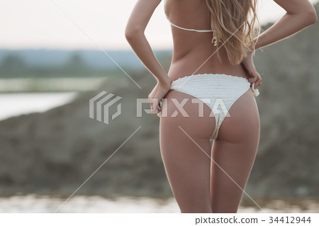 Girl on the sandy beach in a bathing suit 34412944