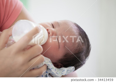 Sleeping newborn baby drinking a milk from bottle Sleeping newborn baby drinking a milk from bottle 34413459