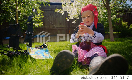 Little boy wearing pirate costume is drinking toy Little boy wearing pirate costume is drinking toy 34415337