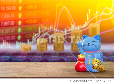 lucky cat bank on wooden table with blur stock. lucky cat bank on wooden table with blur stock. 34417047