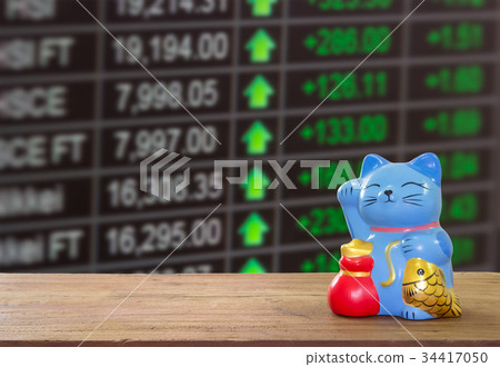 lucky cat bank on wooden table with blur stock. lucky cat bank on wooden table with blur stock. 34417050