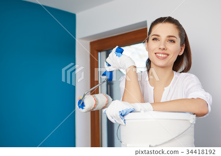 the woman paints and repairs the room 34418192