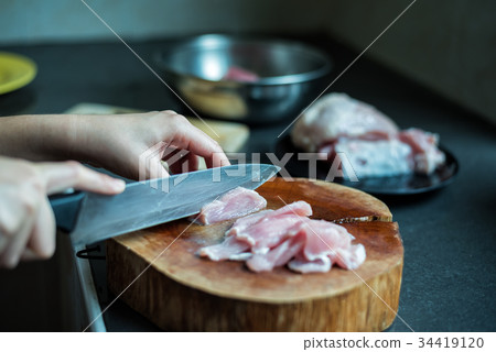 female cook cutting pork on kitchen female cook cutting pork on kitchen 34419120