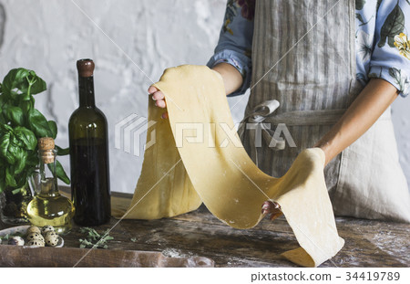 Young woman in apron holding dough Young woman in apron holding dough 34419789