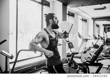 guy relaxing after workout and hold or drink water 34421583