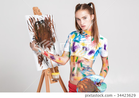 woman painter soiled in colorful paint draws on 34423629