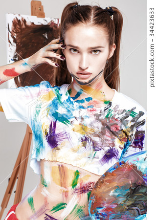 woman painter soiled in colorful paint draws on 34423633