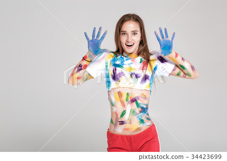 young woman smeared in multicolored paint. young woman smeared in multicolored paint. 34423699