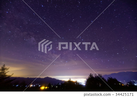從Yatsugatake山脈,山看到的甲府盆地的夜景和滿天星斗的天空。 從Yatsugatake山脈,山看到的甲府盆地的夜景和滿天星斗的天空。 34425171