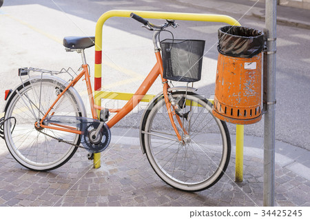 Trash metal orange waste and bicycle 34425245