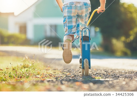 Boy with push scooter 34425306