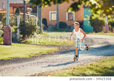 Boy with push scooter 34425308