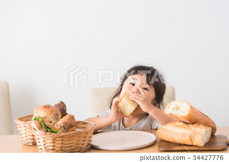 A child holding a bread 34427776