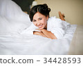 Joyful bride in the morning on the bed in bathrobe 34428593