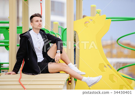 young fashionable man takes in the playground 34430401
