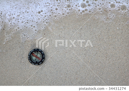 Compass in the sand on the beach. Compass in the sand on the beach. 34431274