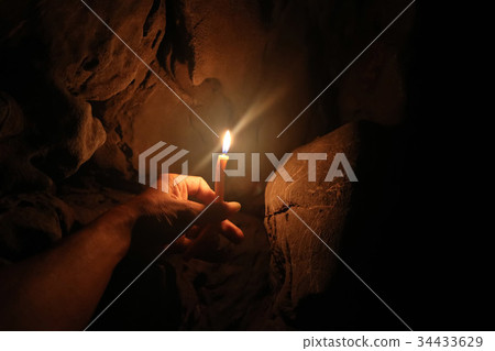 Lighting candles on hand in the limestone caves 34433629