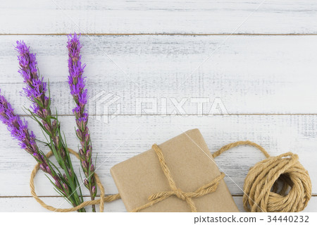 Brown gift box and rope with violet liatris flower Brown gift box and rope with violet liatris flower 34440232