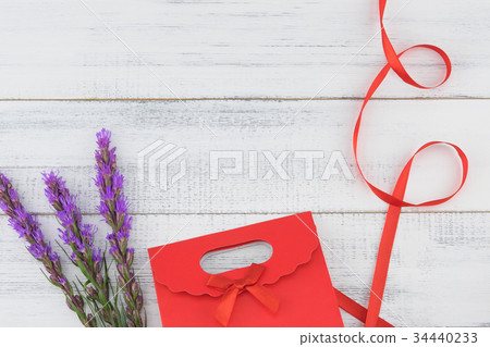Red gift bag decorated with violet liatris flowers Red gift bag decorated with violet liatris flowers 34440233