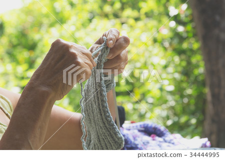 The old woman knits woolen clothes. 34444995