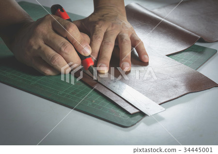 Close-up of male hand cutting with a knife Close-up of male hand cutting with a knife 34445001