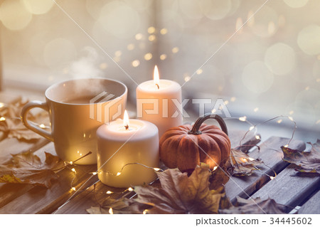 cup of coffee or tea near a pumpkin and candles cup of coffee or tea near a pumpkin and candles 34445602