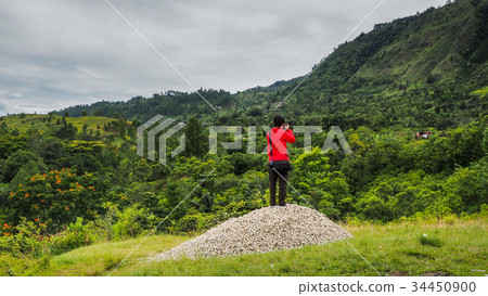 man standing on hill looking at the lake toba man standing on hill looking at the lake toba 34450900